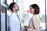 Businessman and businesswoman with coffee to go outdoors