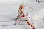 Blond woman having a snack on stairs