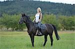 Smiling woman sitting on horse