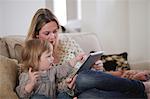 Mother with daughter pointing at digital tablet