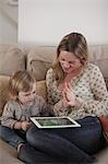 Mutter und Tochter spielen mit digitalen tablet