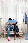 Couple hiding behind books