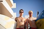 Deux jeunes hommes à la plage avec des planches de surf