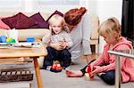 Mother playing with children, boy on cell phone