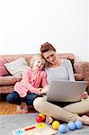 Mother using laptop with daughter