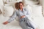 Woman wearing pyjamas reclining in bed