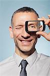 Man with smartphone over eye