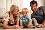 Father, mother and son using digital tablet