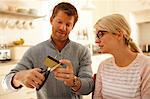 Couple cutting credit card with scissors