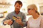 Couple cutting credit card with scissors