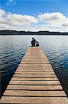Couple sur vacances assis ensemble romantique lac Ianthe, île du Sud, Nouvelle-Zélande, Pacific