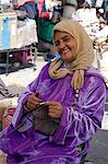 A woman in traditional dress knitting wool hats in the souk, Marrakech, Morocco, North Africa, Africa