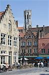 Stepped Flemish gables over street cafes with the Belfry by the Market Square behind, Brugge, UNESCO World Heritage Site, Belgium, Europe
