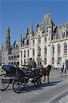 Un ramasseherbe hippomobiles conduit devant l'édifice de la Cour provinciale à la place du marché, Brugge, patrimoine mondial de l'UNESCO, Belgique, Europe
