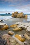 Smooth granite boulders on the sandy beach at Porth Nanven, Cornwall, England, United Kingdom, Europe