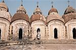 Woman with broom emerging from one of 108 Shiva temples built by Maharaja Teja Chandra Bahadur in 1809, Kalna, West Bengal, India, Asia