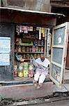 Shop owner reading the newspaper in the morning, Kolkata, West Bengal, India, Asia