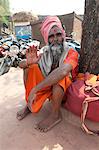 Travelling saddhu dressed in holy colour orange, resting beneath a village tree, Bhubaneshwar, Orissa, India, Asia