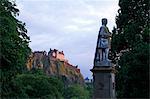 Statue of Allan Ramsay, with Edinburgh Castle at sunset from West Princes Street Gardens, Edinburgh, Scotland, United Kingdom, Europe
