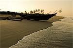 Lever du soleil sur le bateau de pêche traditionnel et plage de Benaulim, Goa, Inde, Asie