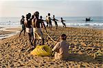 Fishermen hauling in nets at sunrise, Chowara Beach, near Kovalam, Kerala, India, Asia