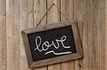 Love Written in Cursive on Chalkboard and Hanging on Wooden Wall