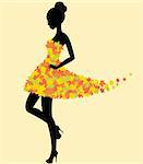 Silhouette of the young beautiful dancer girl in dress of autumn leaves