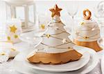 Festive table for Christmas with small tree in white and golden tones