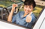 Happy Smiling Mixed Race Woman in Car with Thumbs Up Holding Set of Keys.