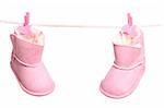 Pair of pink winter boots hanging on the clothesline. Image isolated on white background