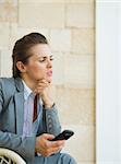 Concerned business woman holding mobile phone