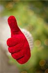 Woman in Sweater with Seasonal Red Mittens Holding Out a Thumb Up Sign with Her Hand.