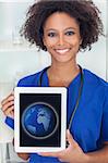 An African American female woman medical doctor with a tablet computer in hospital with a world map or globe on the screen