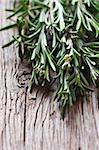 Bunch of fresh rosemary on a wooden background,