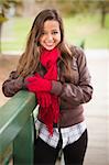 Pretty Festive Smiling Woman Portrait Wearing a Red Scarf and Mittens Outside.