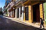 Woman Walking Past Brightly-Colored Buildings, Havana, Cuba