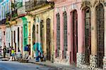 People Hanging Out on Street in front of Multi-Colored Buildings, Havana, Cuba