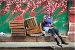 Smoking Woman Sitting Beside Empty Crates on Curb, Havana, Cuba