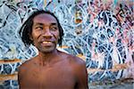 Portrait of Man in front of Wall Covered in Grafitti, Havana, Cuba