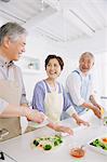 Three senior adult people attending a cooking class in an open kitchen