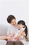 Grandmother and granddaughter smiling on the sofa