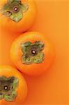 Japanese Persimmons on orange background