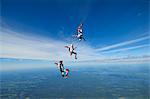 Three parachute jumpers in the sky, Sweden.