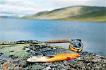 Fishing rod and char with lake in background