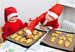 Brother and sister wearing Santa hats baking saffron rolls