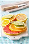 Close-up of Slices of Citrus Fruits on Cutting Board on Blue Background