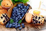 Muffins with blueberry, egg and flour on wooden table