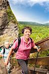 happy asian senior couple hiking in the mountain