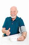 Senior man succeeds in lowering his blood pressure and gives a thumbs up sign.  White background.