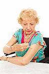 Senior woman giving herself an injection for diabetes, arthritis, etc.  White background.